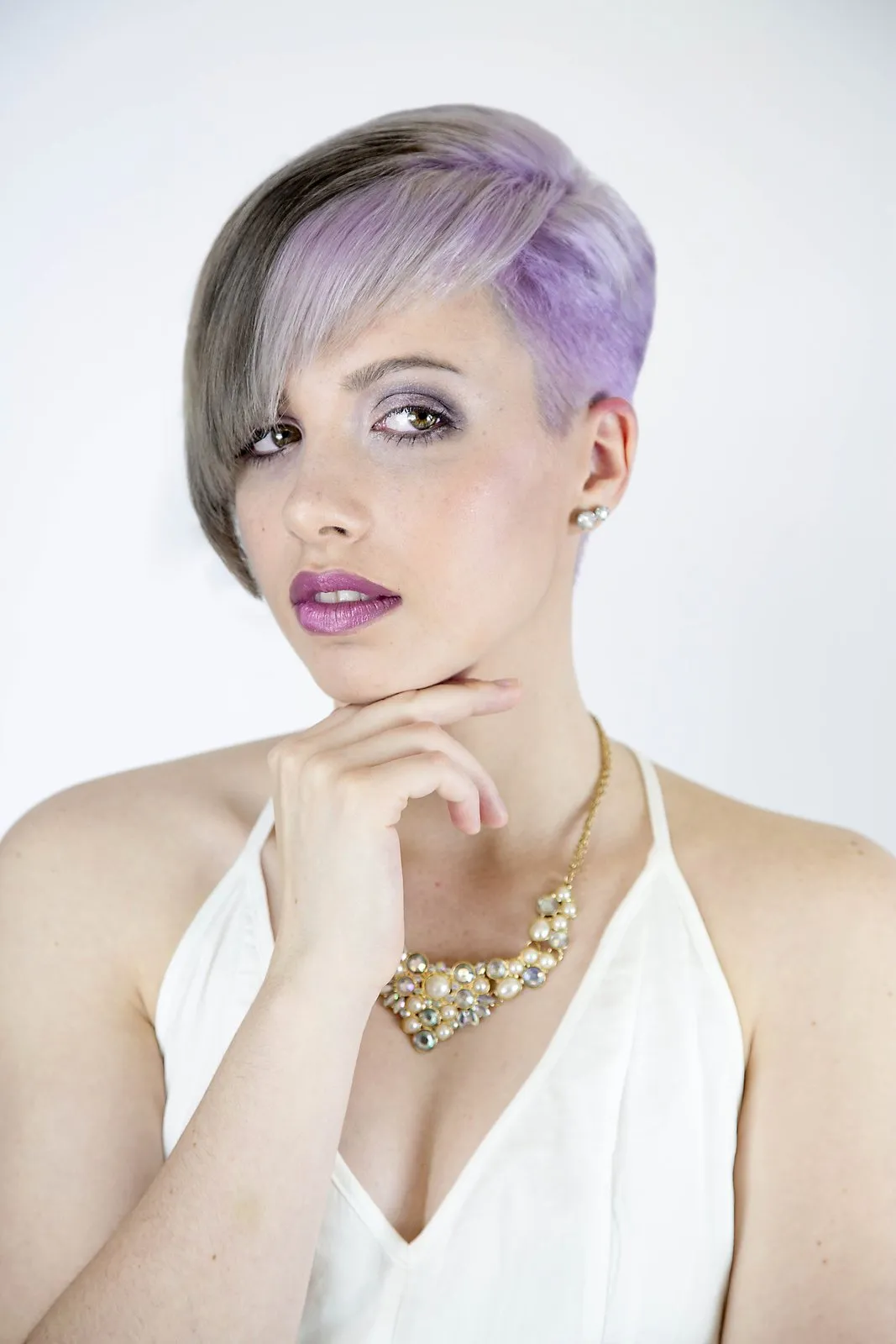 Studio portrait, lilac hair and a gold chain against white